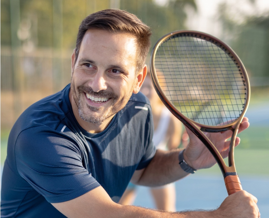 Active man playing tennis after treatment at pain management clinic Oakville Burlington Mississauga.